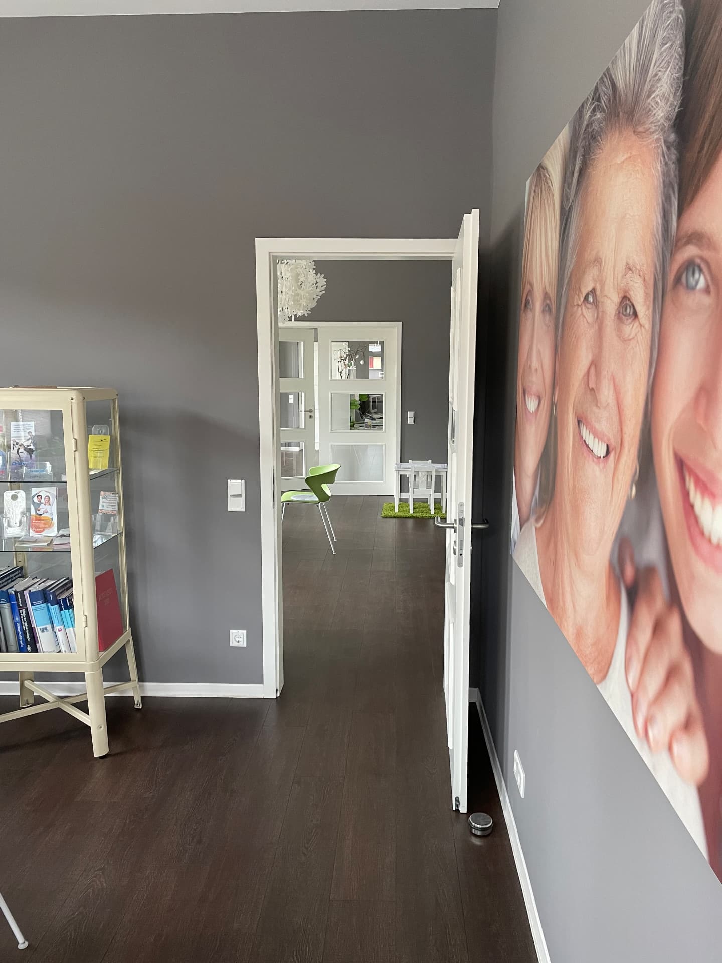 Praxisflur mit großem Bild von drei lächelnden Frauen
